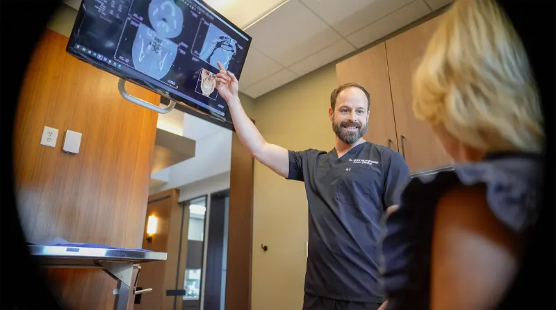 Dentist reviewing a 3D scan on screen with a patient